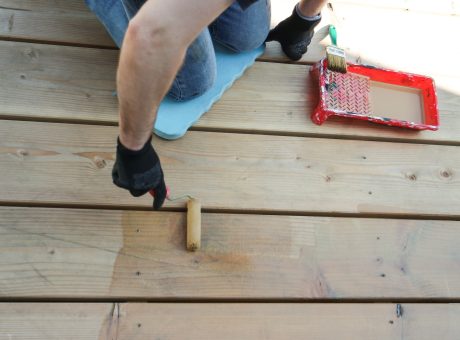 Home improvement, man painting wooden deck.